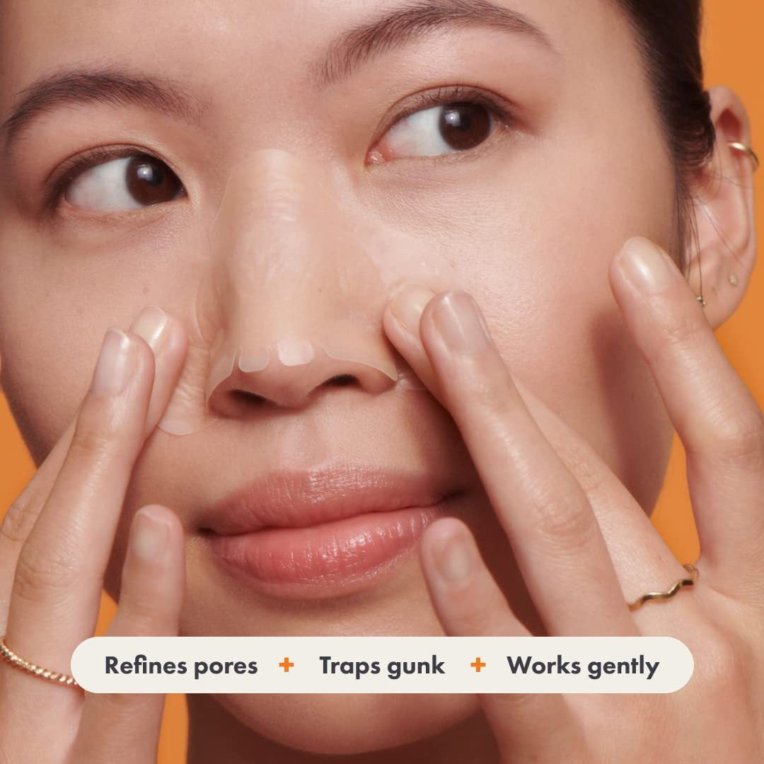 Woman applying facial care acne nasal stickers for pore refinement and gunk removal.